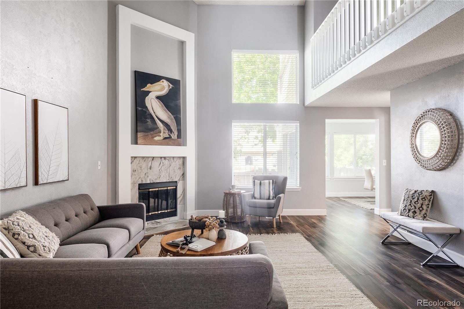 a living room with furniture two window and a fireplace