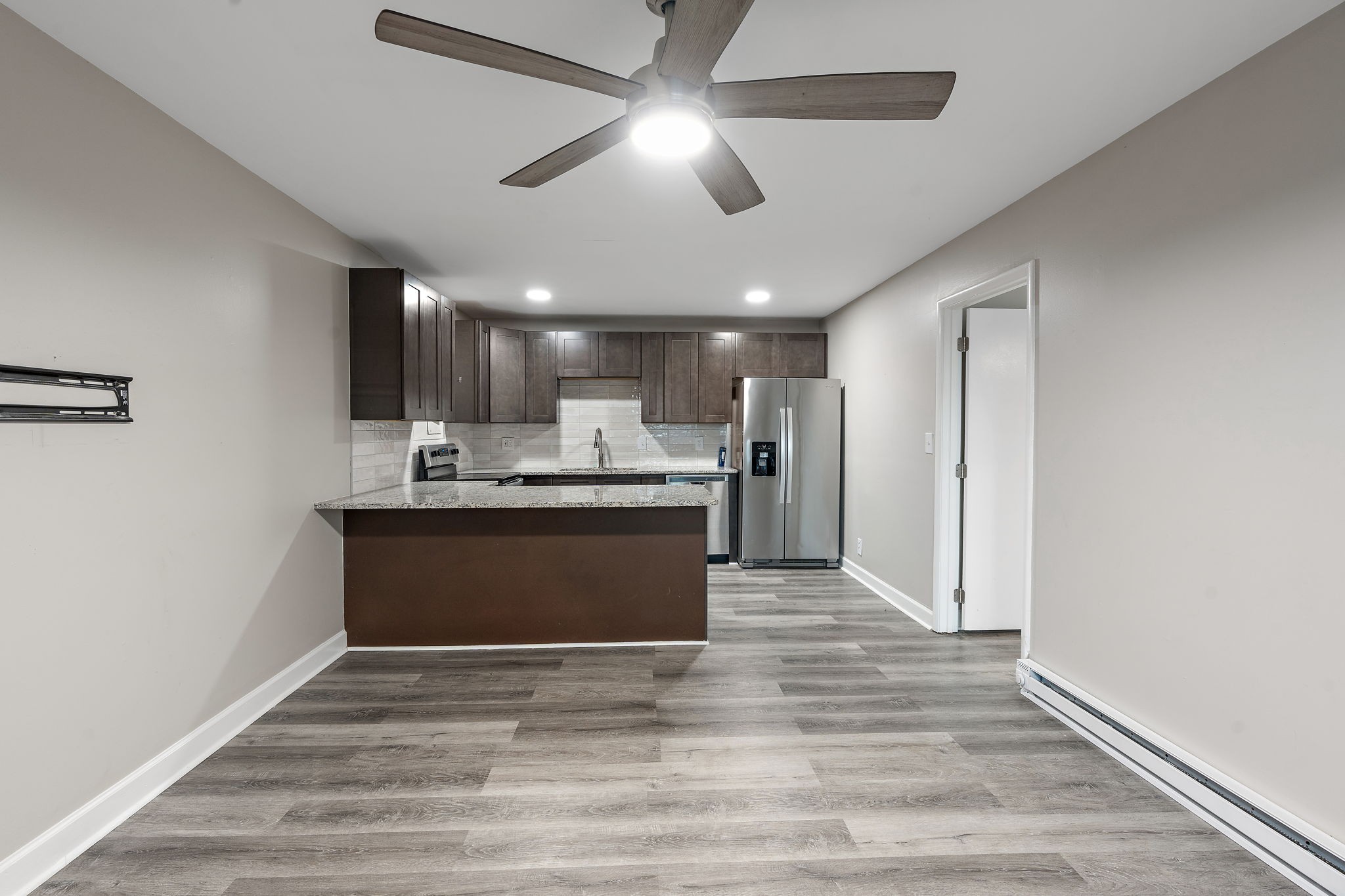 a view of kitchen with kitchen island stainless steel appliances cabinets a sink and a counter top space