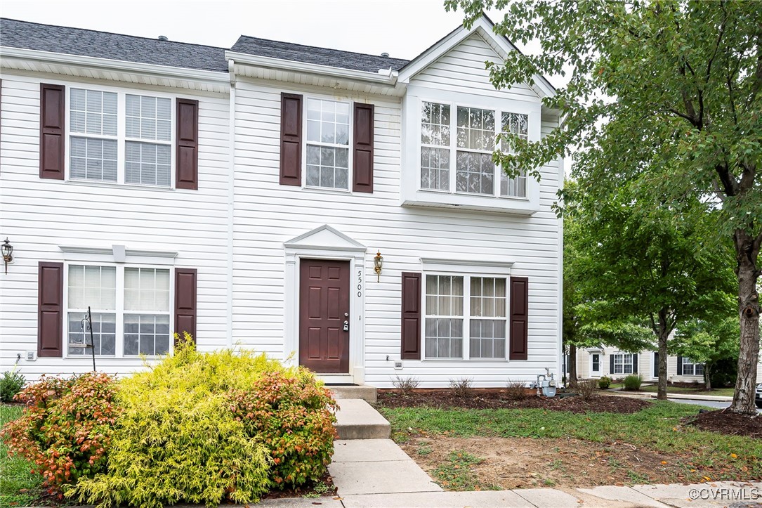 front view of a brick house with a yard