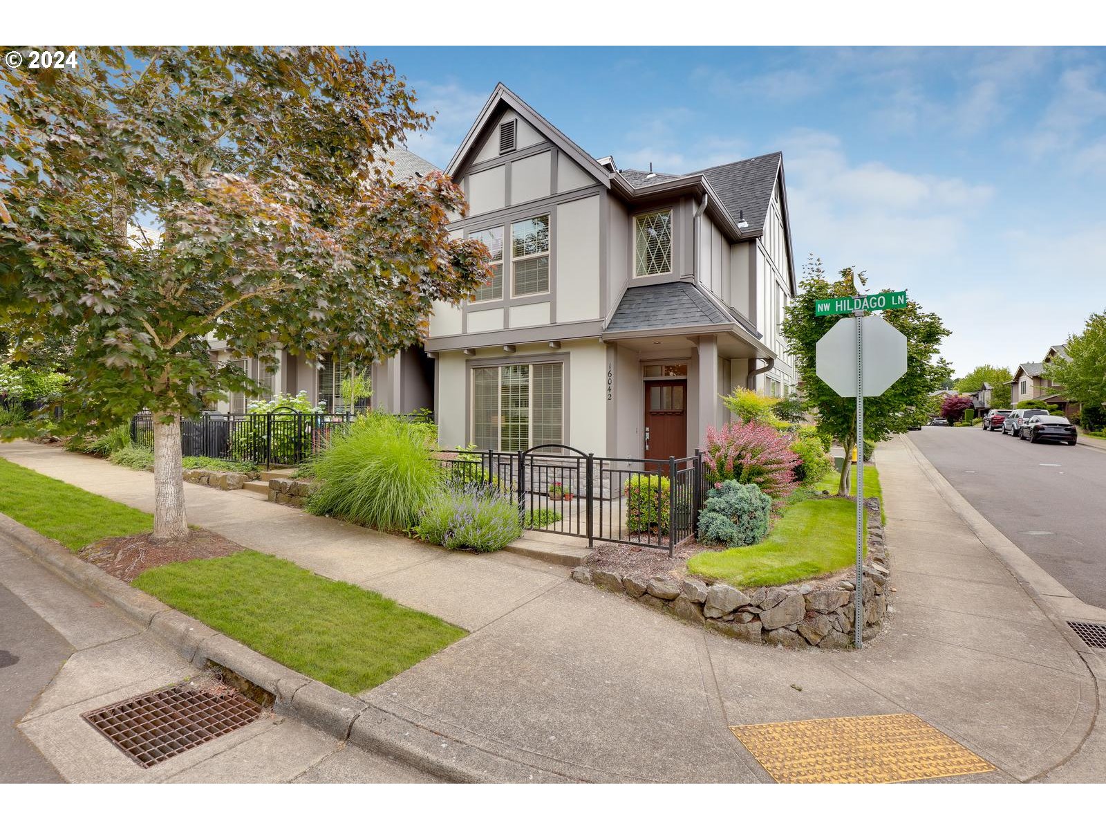 a front view of a house with garden and plants