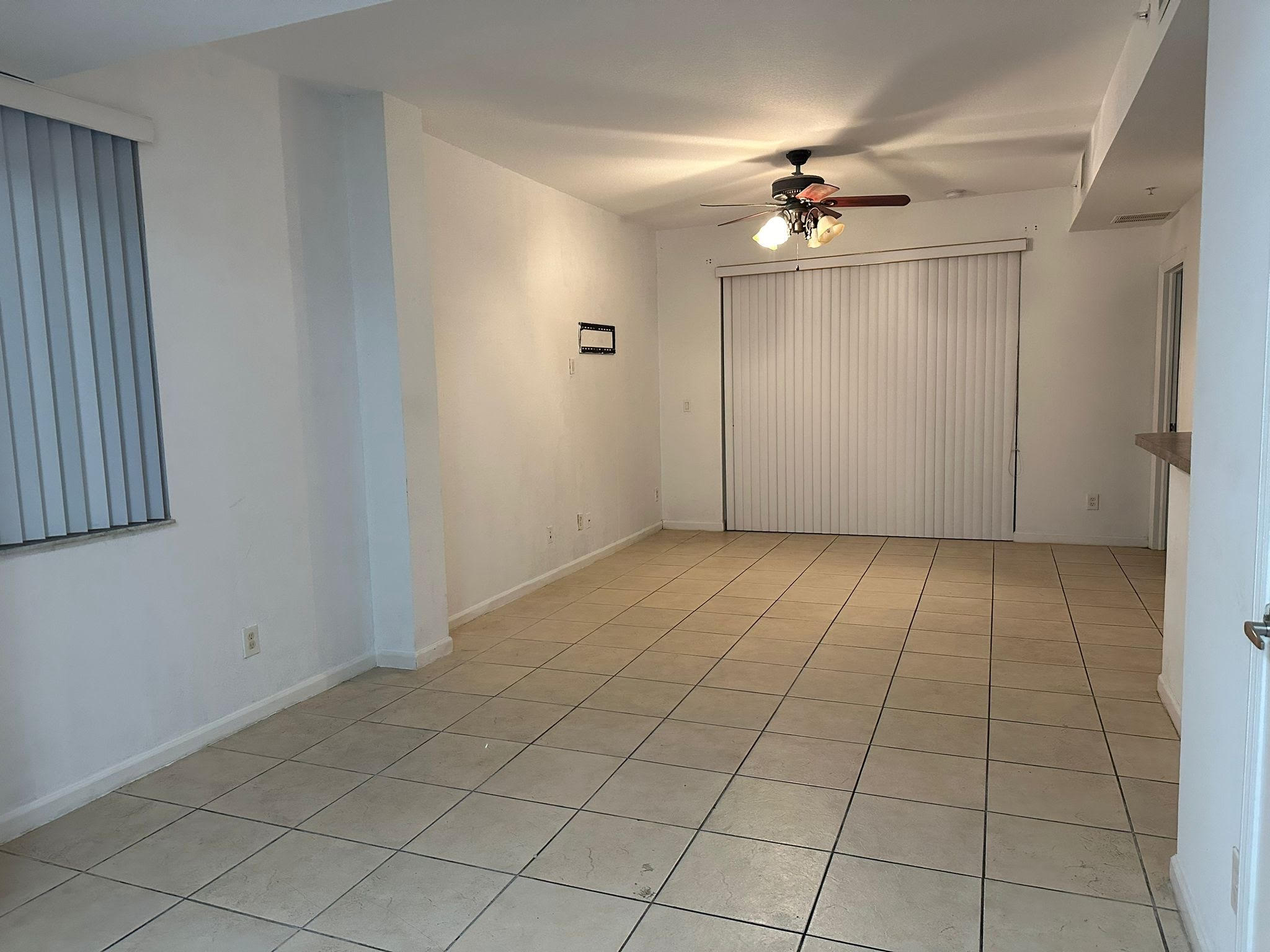 a view of an empty room and a ceiling fan