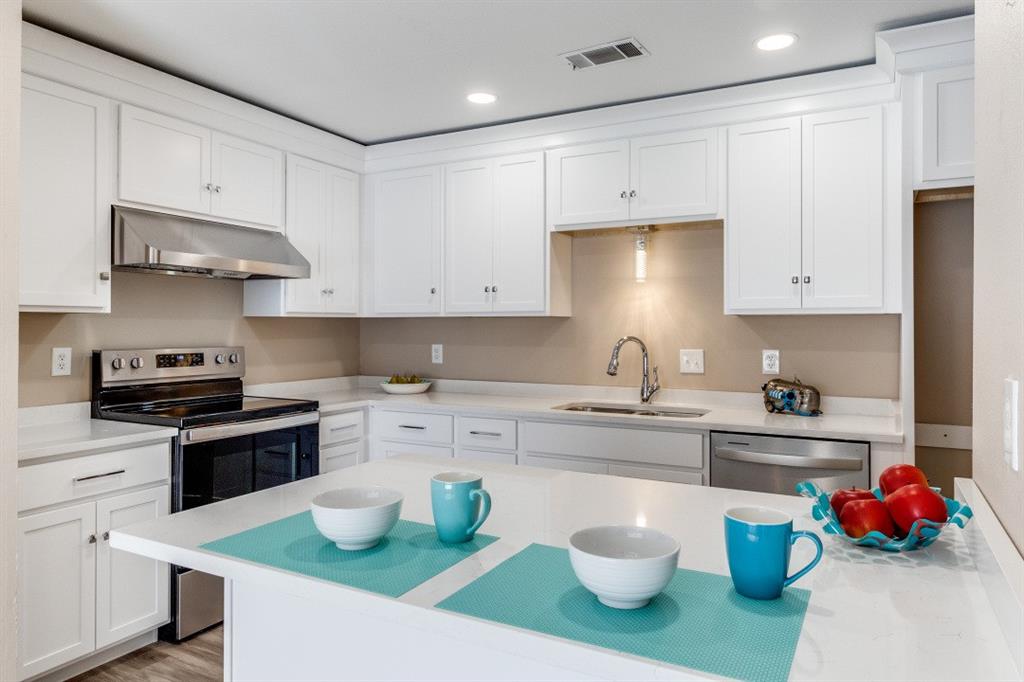 a kitchen with a sink and white cabinets