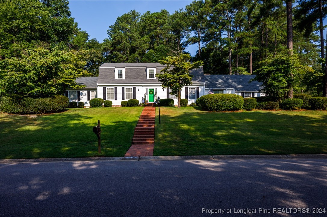 a front view of a house with a garden and yard