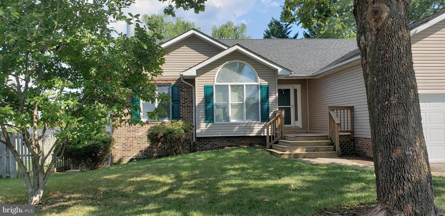 a view of house with backyard and a garden