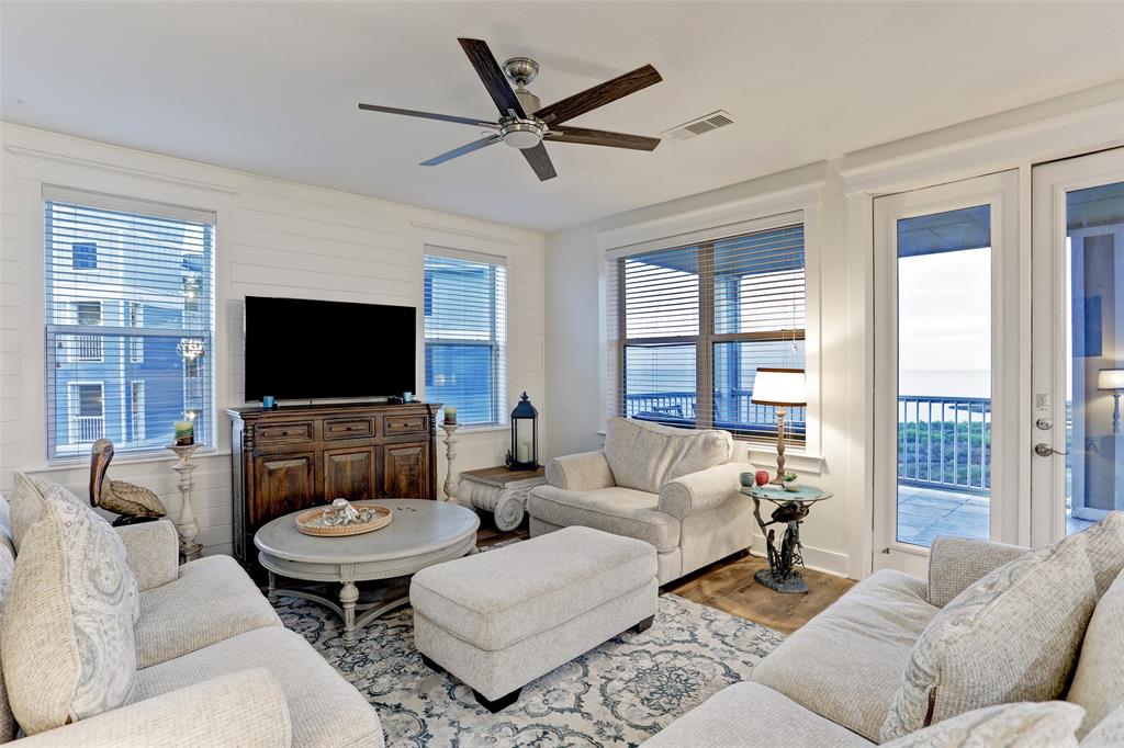 a living room with furniture a flat screen tv and a large window