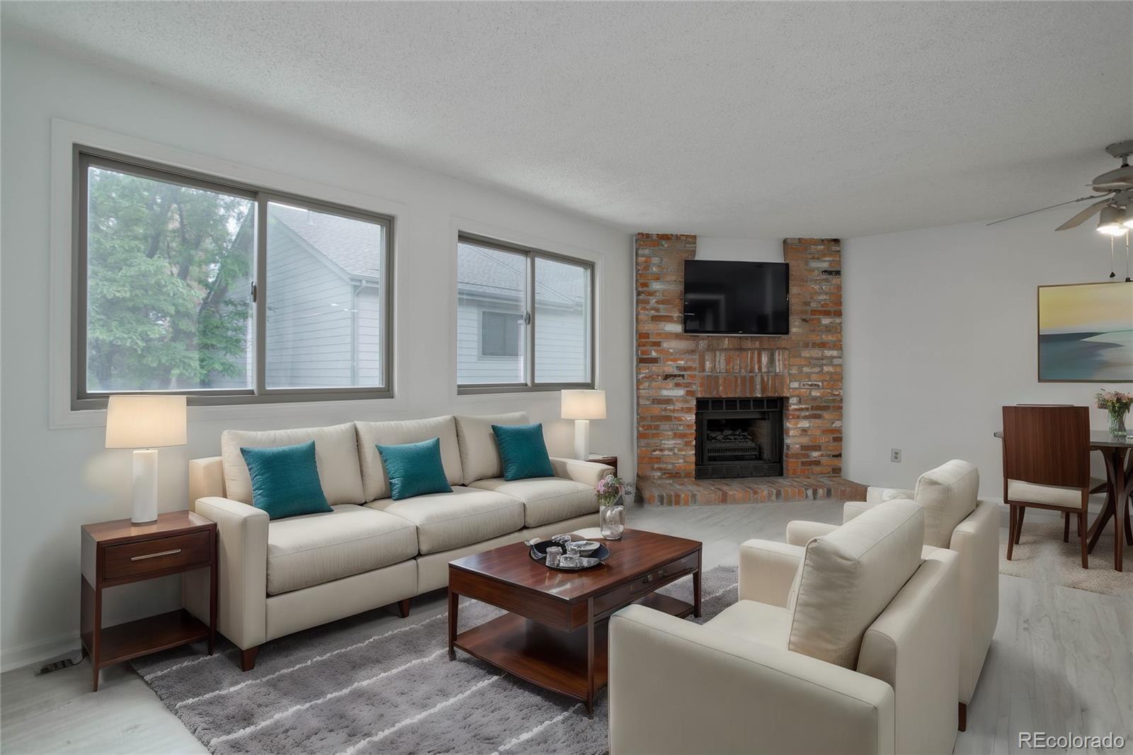 a living room with furniture a flat screen tv and a fireplace