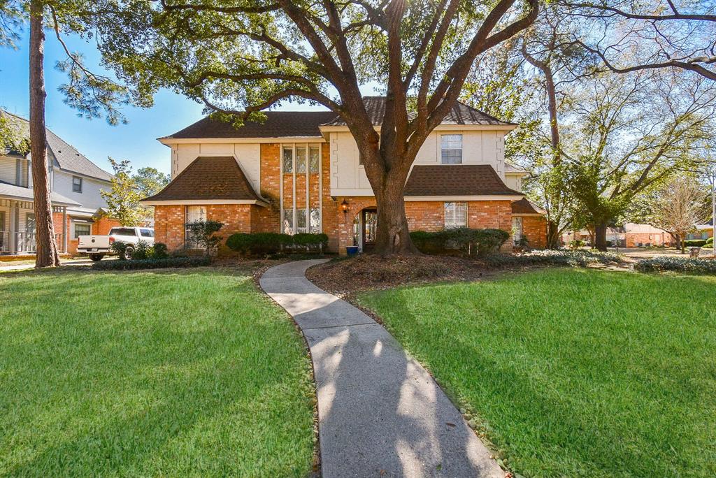 a front view of a house with a yard and trees