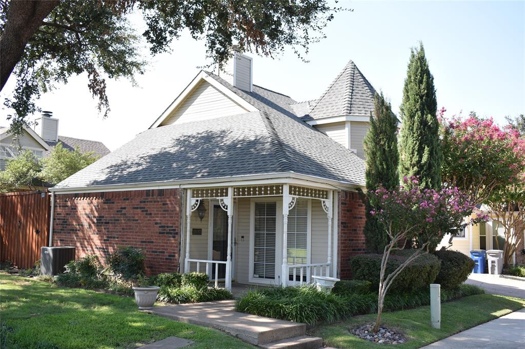 a view of a house with brick walls and a yard with a tree