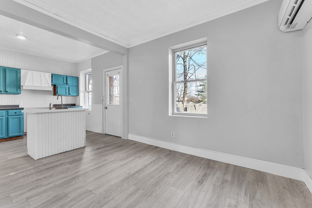 a view of a kitchen with wooden floor and electronic appliances