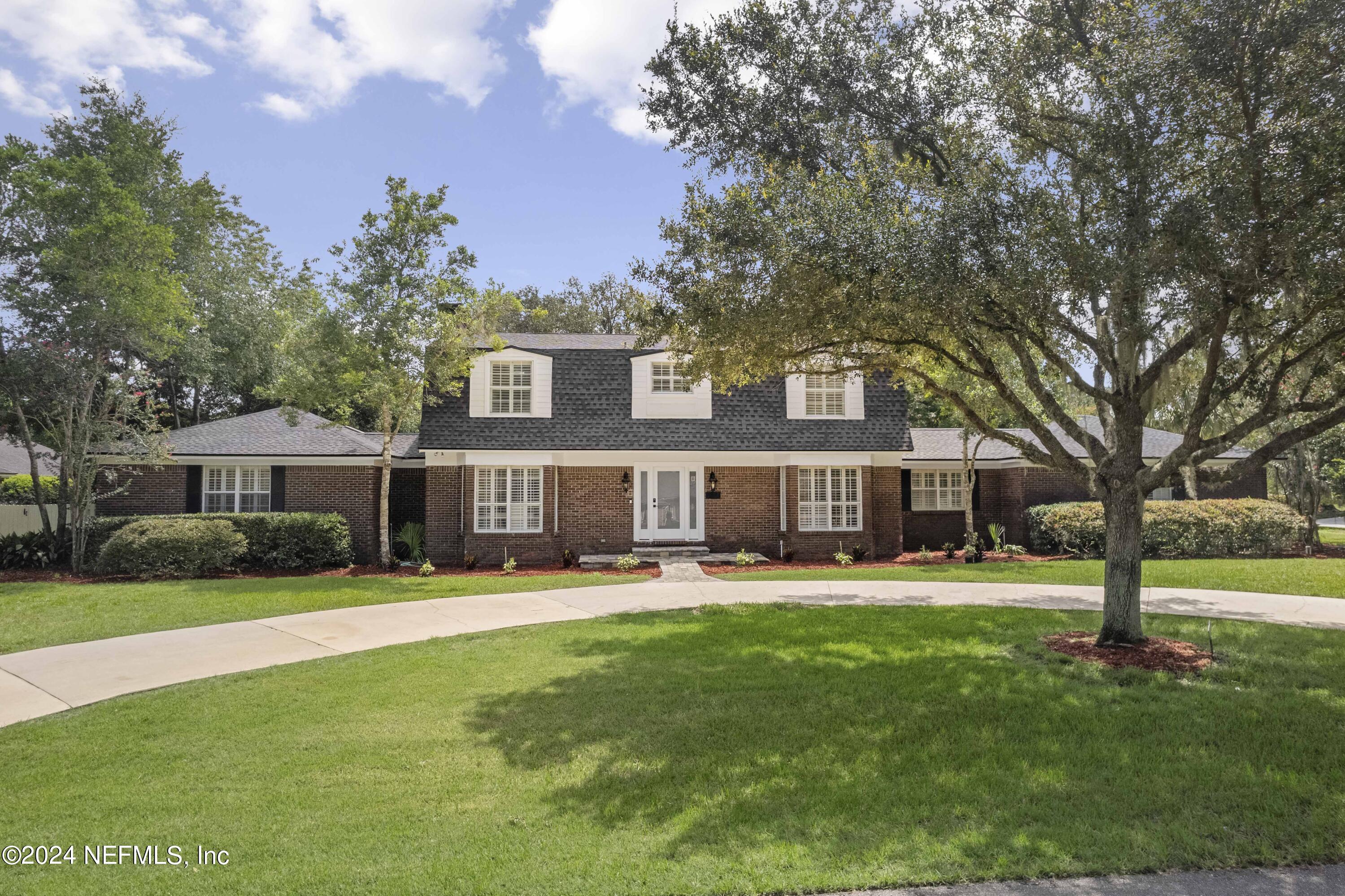 a front view of house with yard and green space