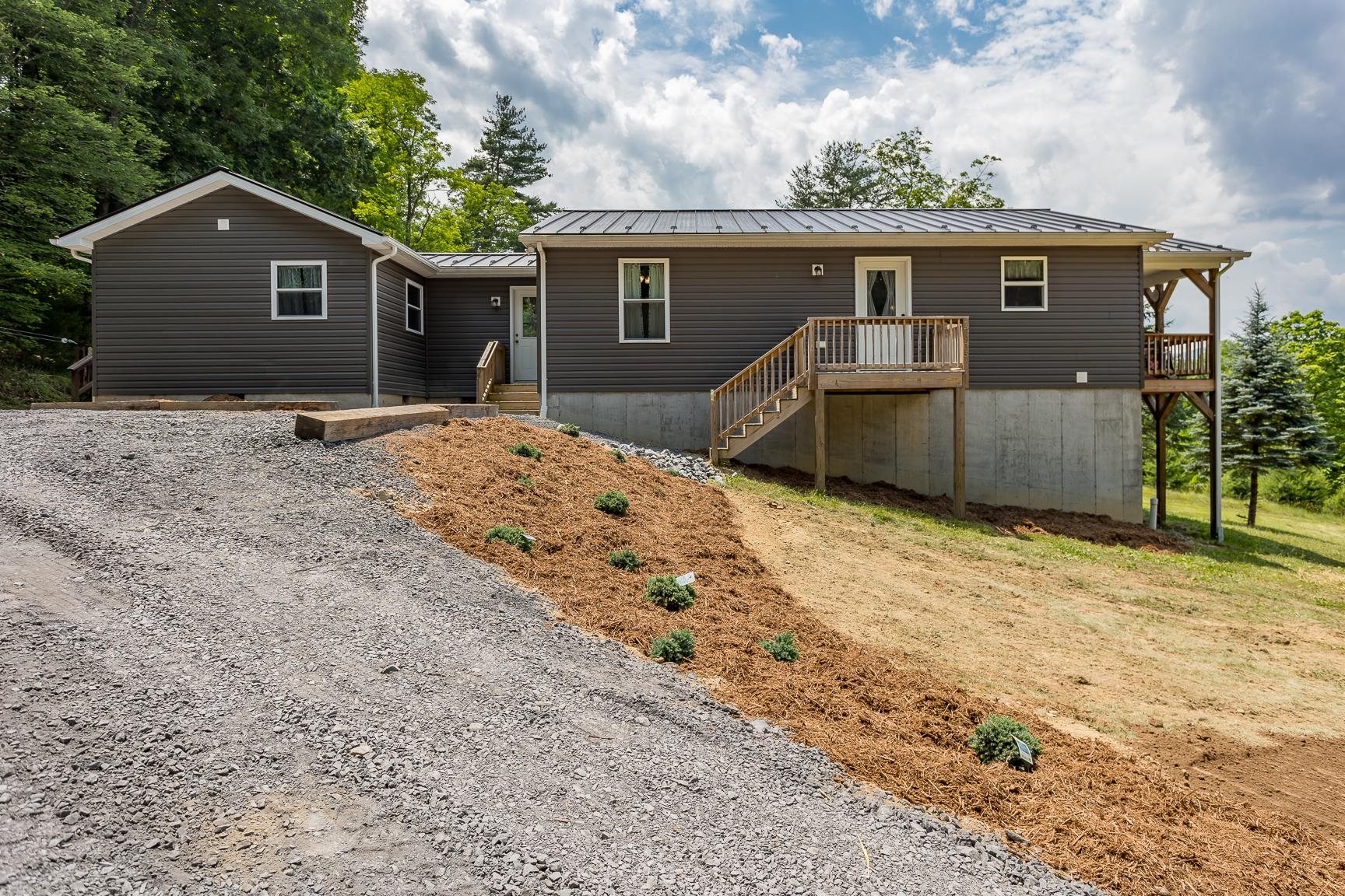 a front view of house with yard and trees in the background