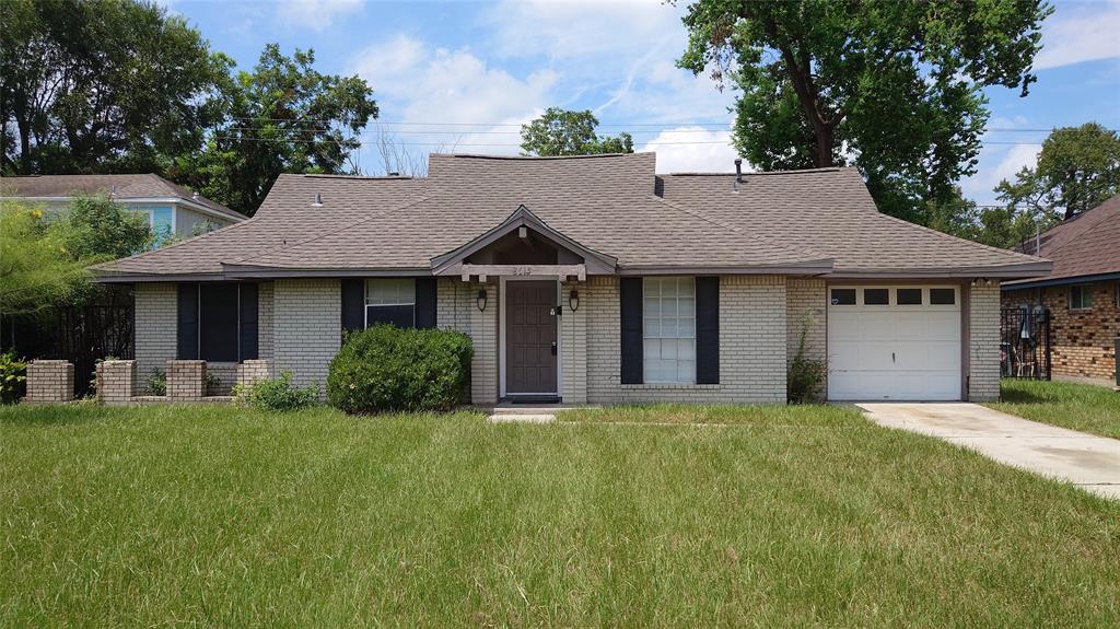 a front view of a house with a garden and yard