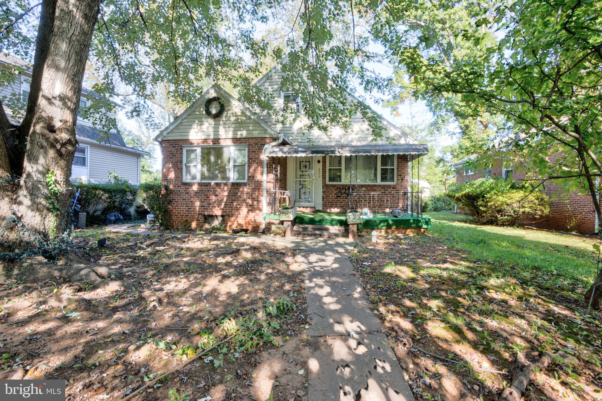 a front view of house with yard and trees around