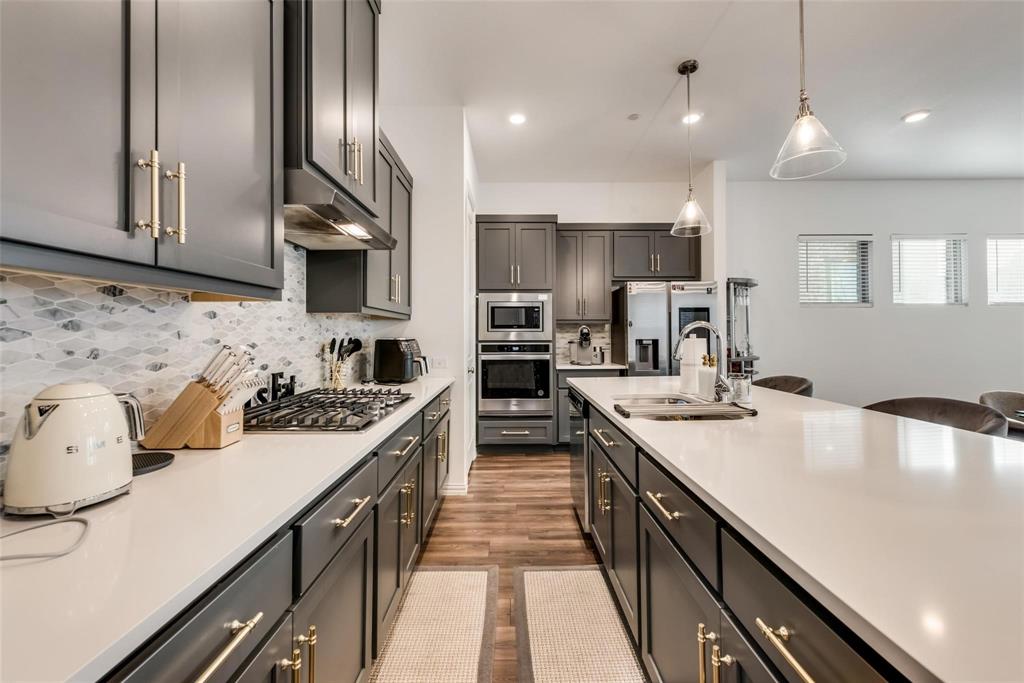 a kitchen with kitchen island granite countertop a sink stove and cabinets