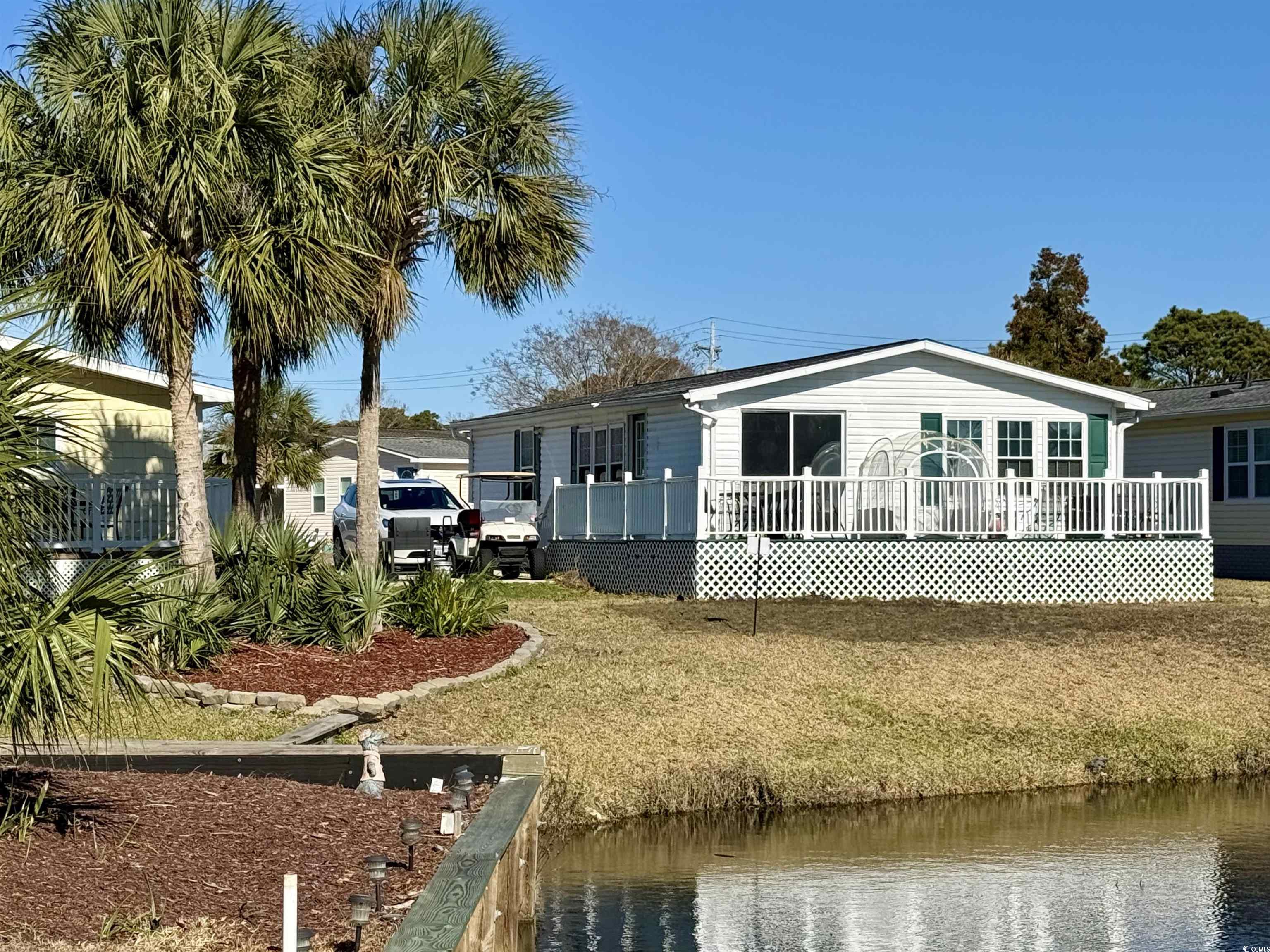 Back of house featuring a yard and a water view