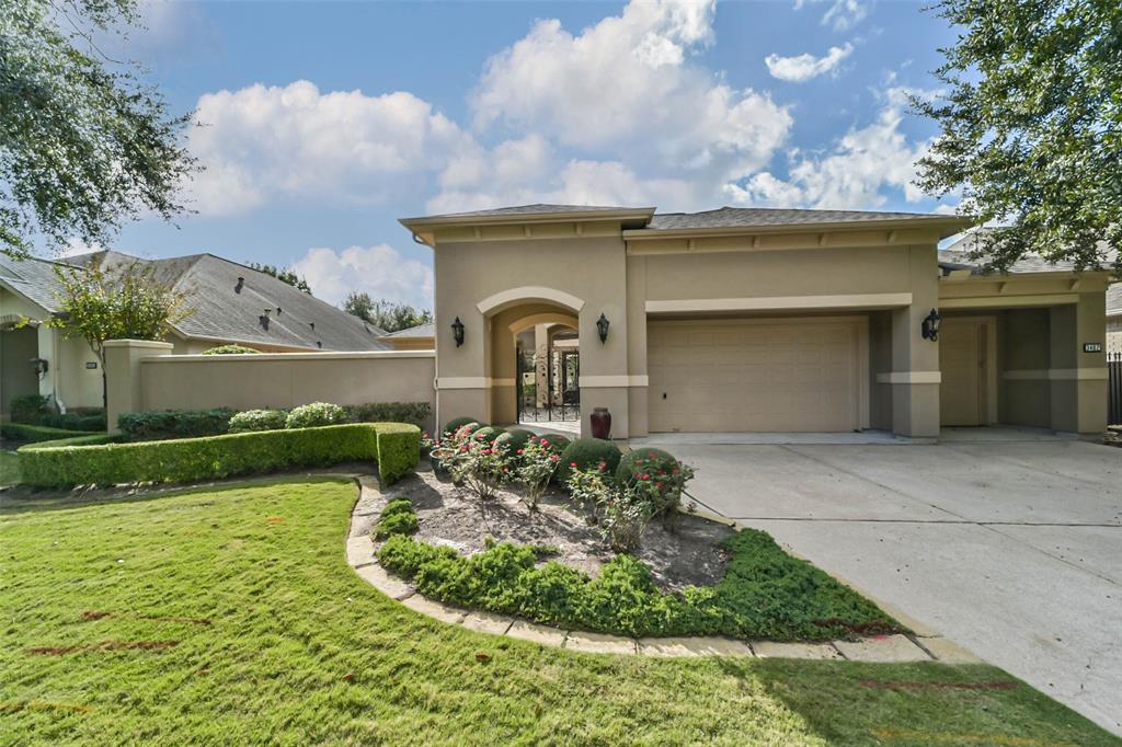 This luxurious one-story stucco home has a spacious three car garage and an elegant arched entryway.