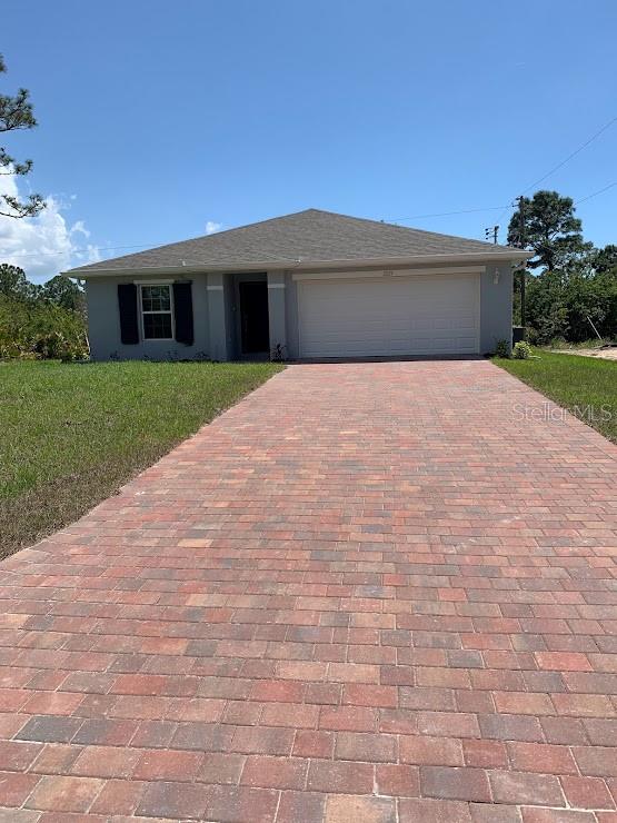 a front view of a house with a yard and a garage