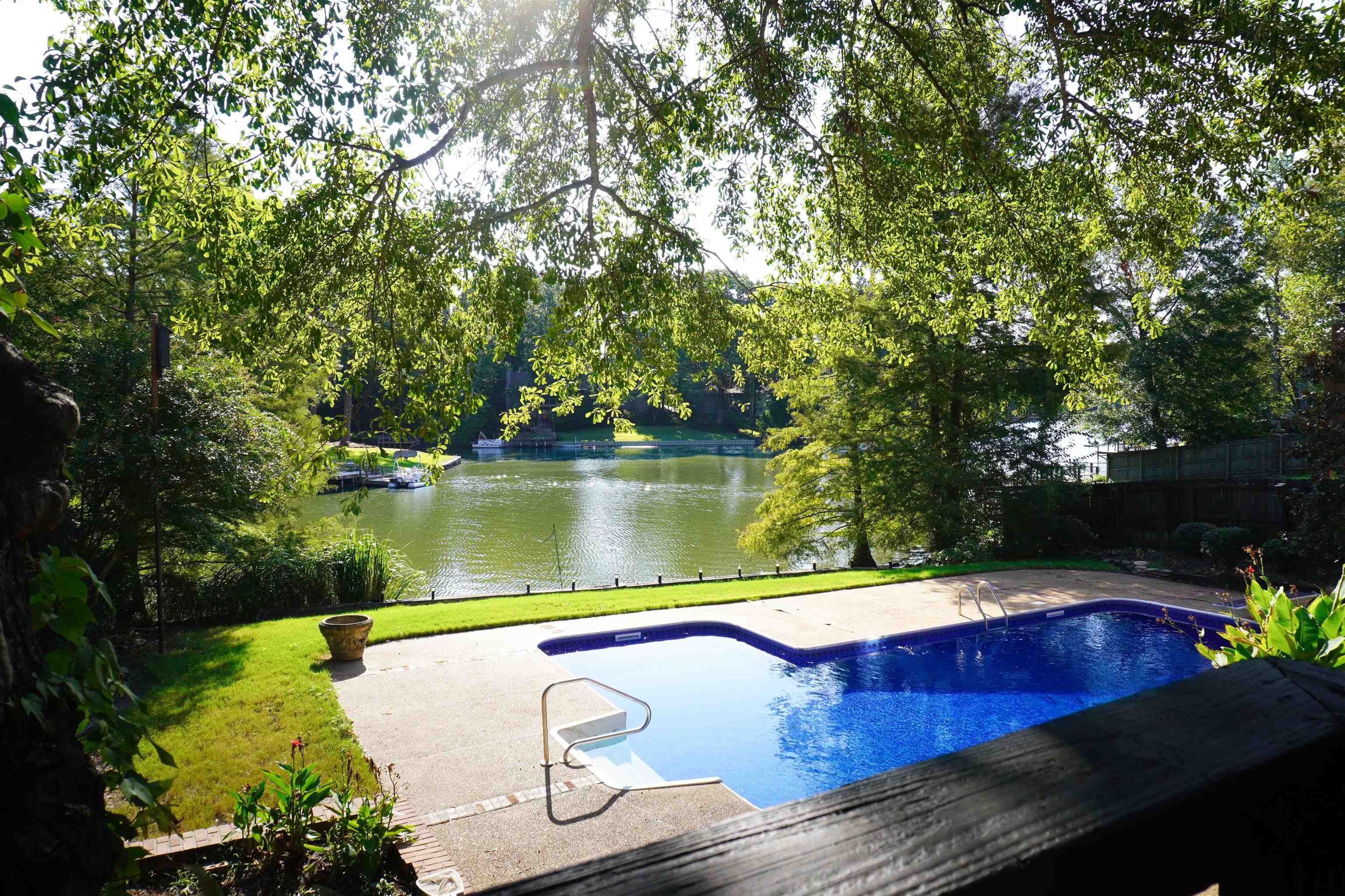 View of swimming pool featuring a yard, a patio, and a water view