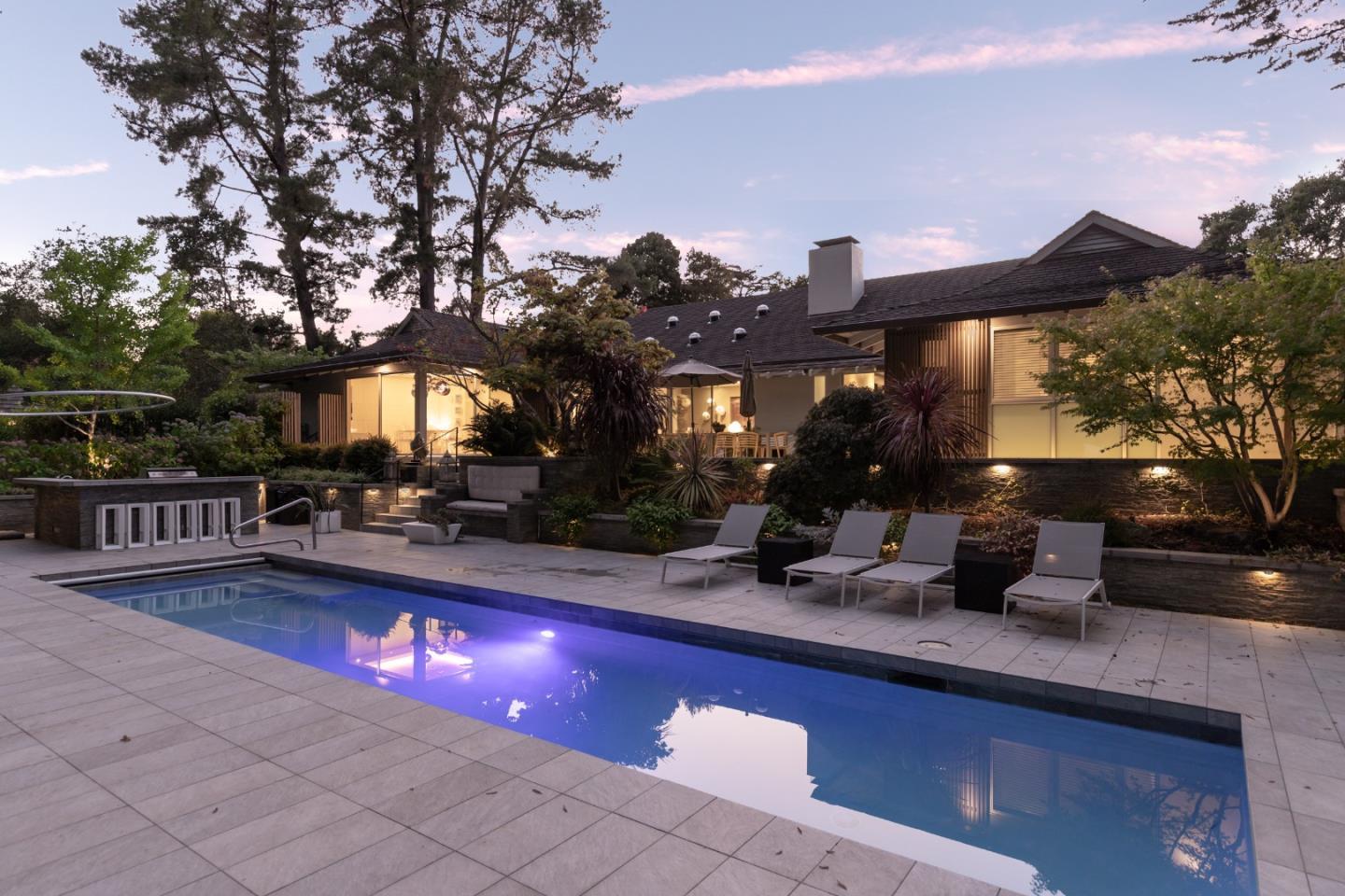 a view of a house with a swimming pool and sitting area