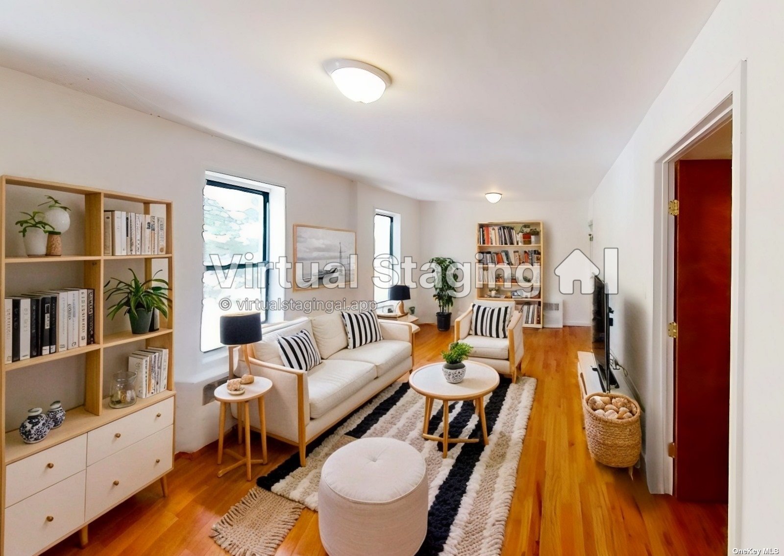 a living room with furniture and a bookshelf with wooden floor