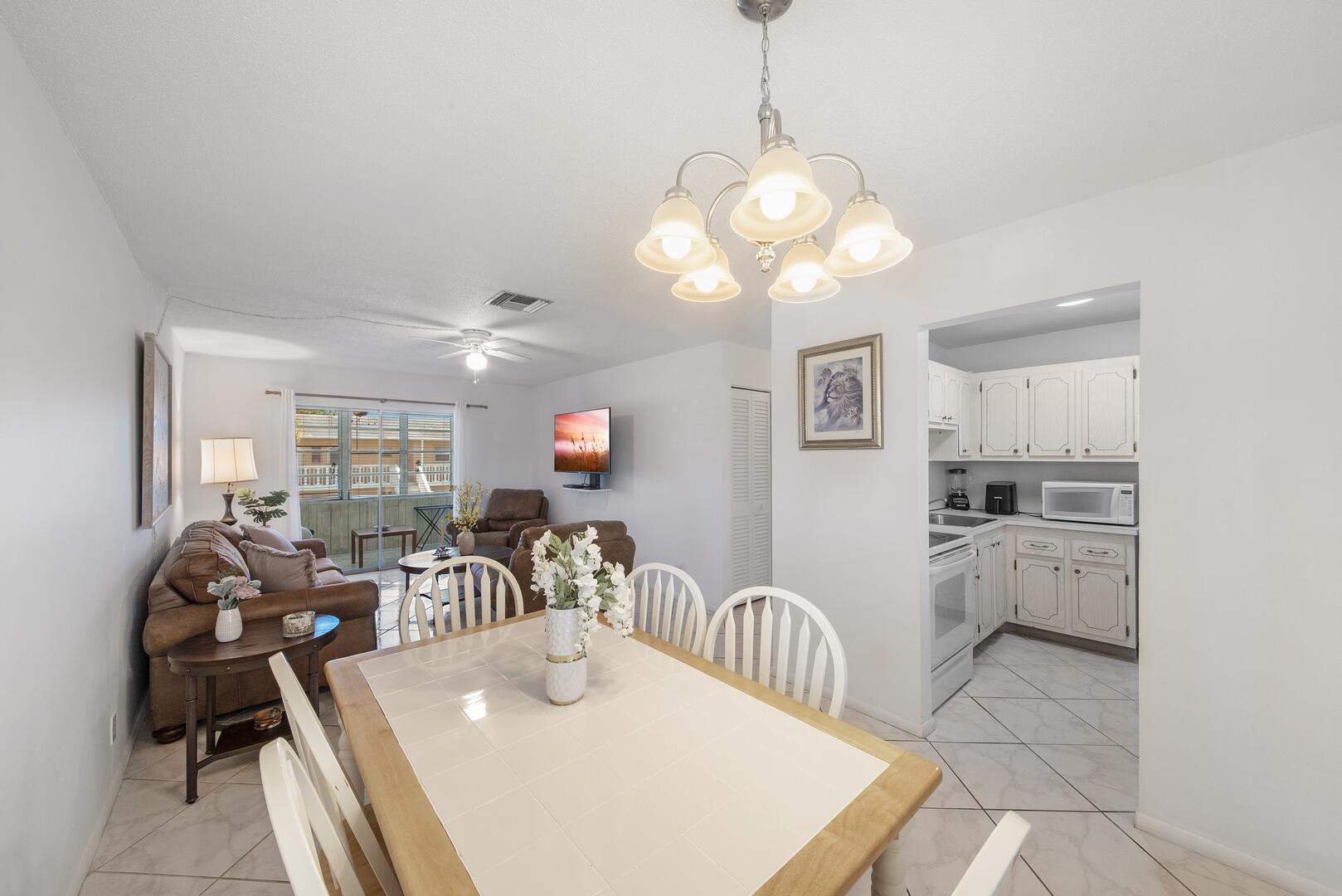 a view of a dining room and livingroom with furniture wooden floor a chandelier