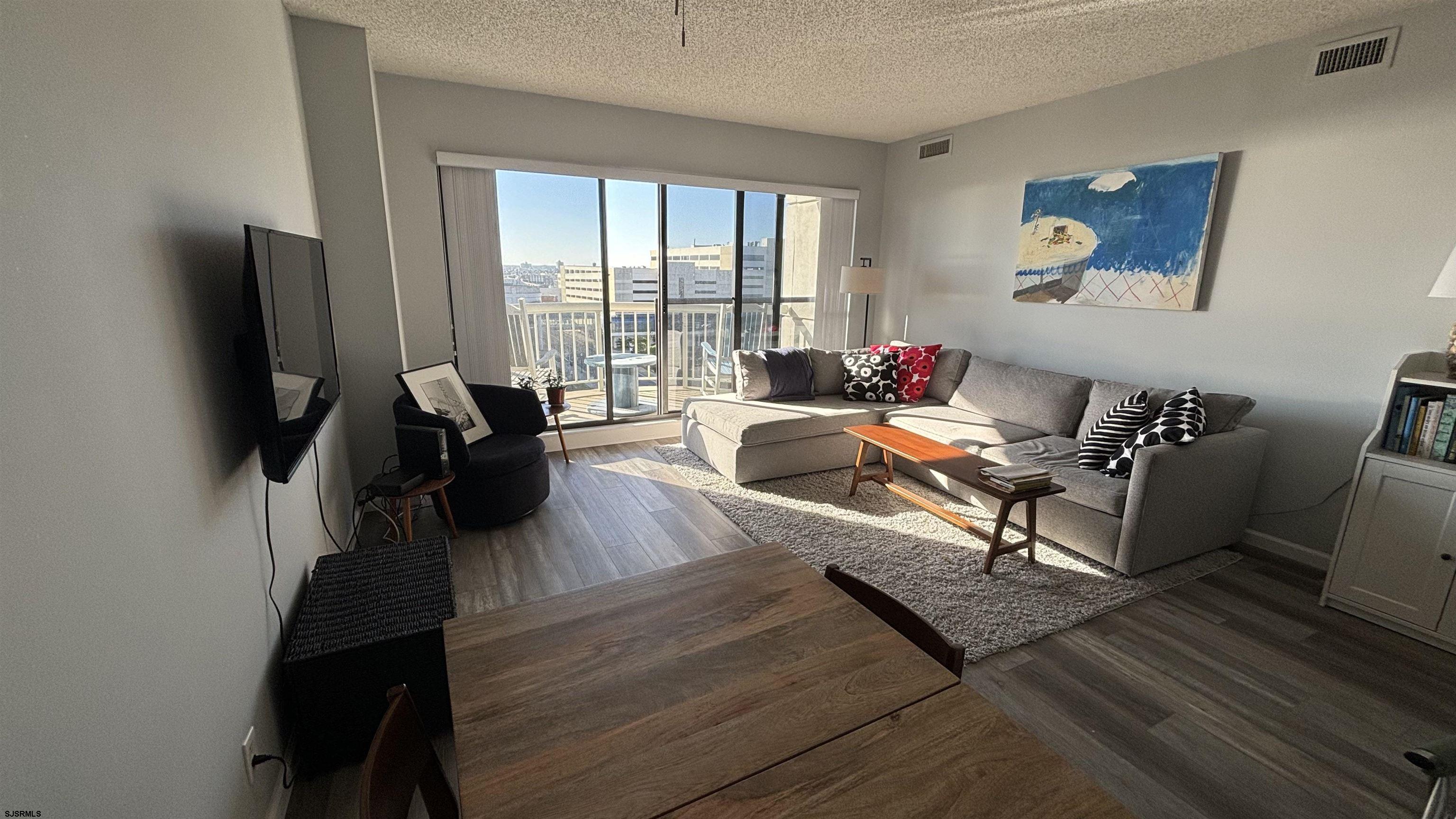 a living room with furniture wooden floor and a flat screen tv