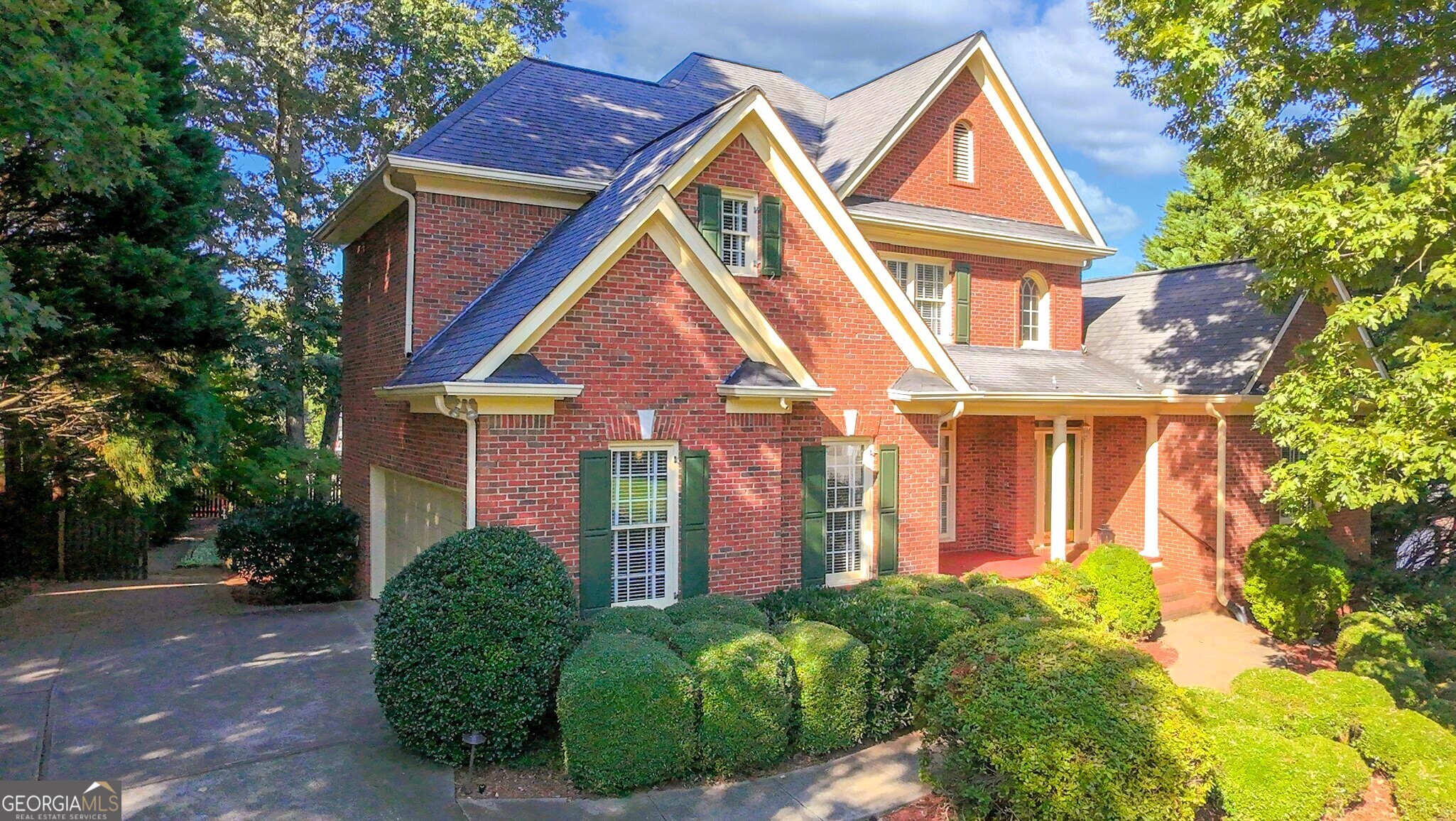 a front view of a house with a yard and trees