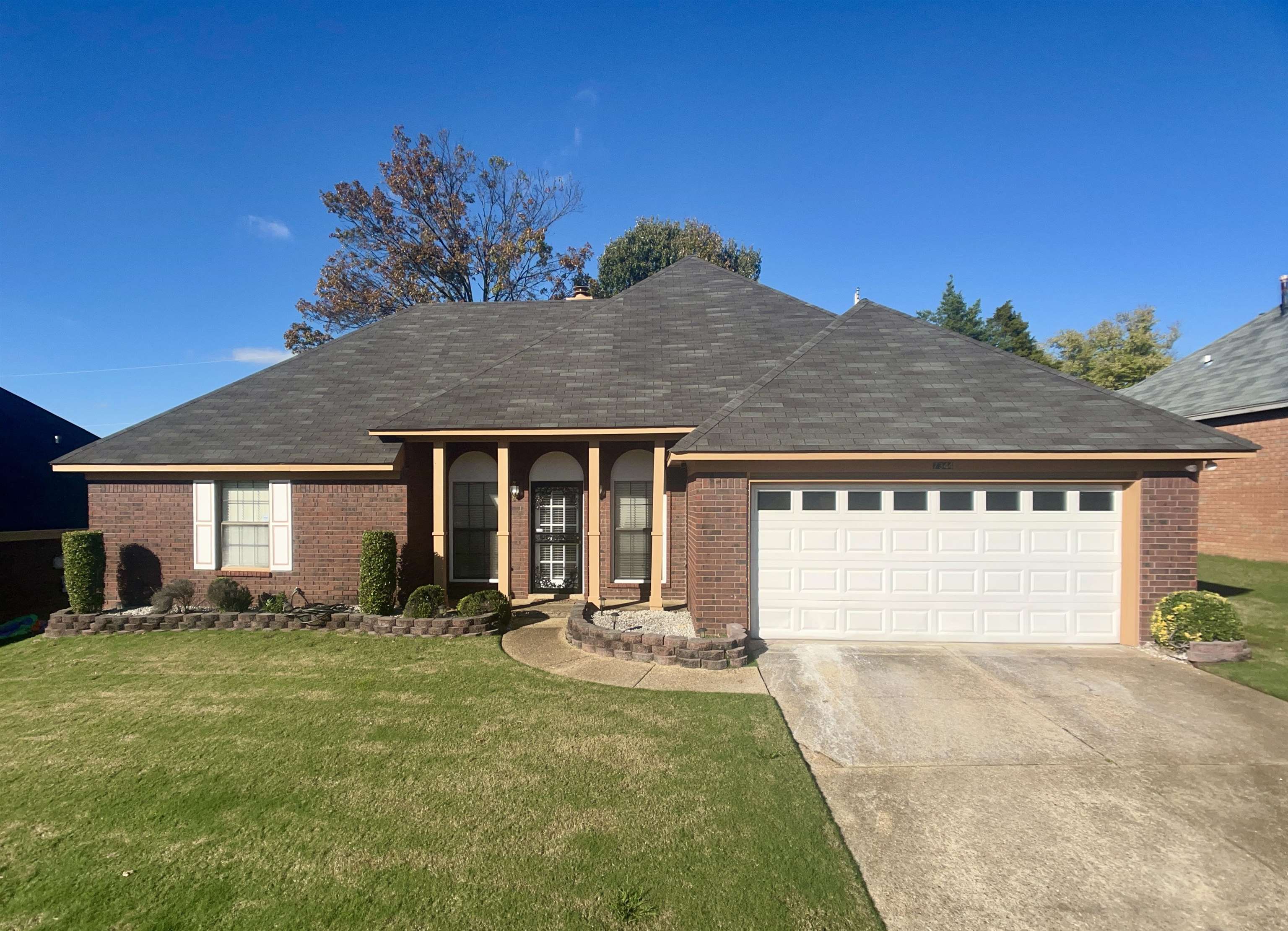 Ranch-style home featuring a front yard and a garage