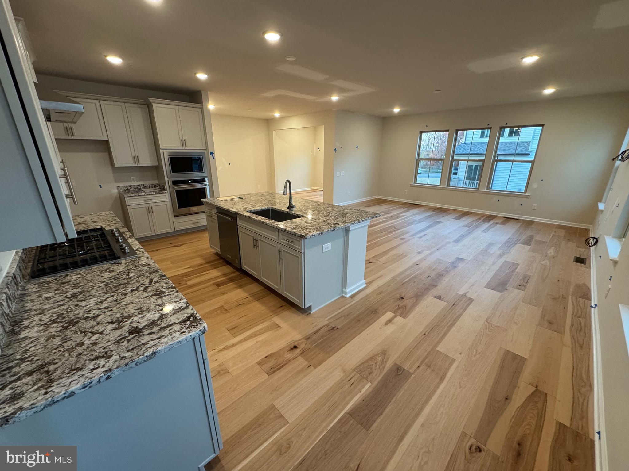 a kitchen with stainless steel appliances granite countertop a stove and a wooden floors