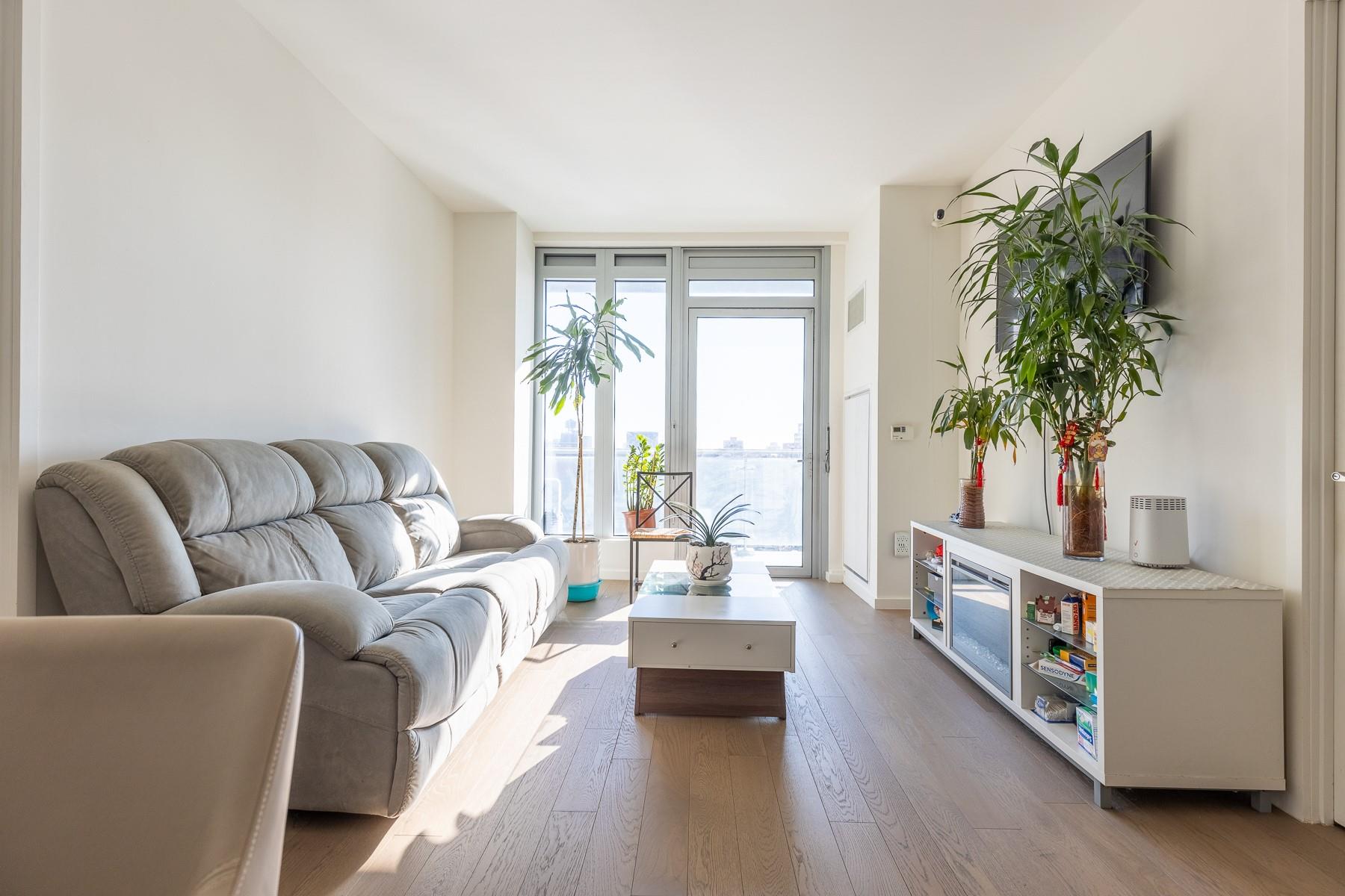 Living room with hardwood / wood-style flooring and a wall of windows