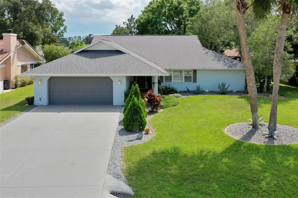 a front view of a house with a yard garage and outdoor seating