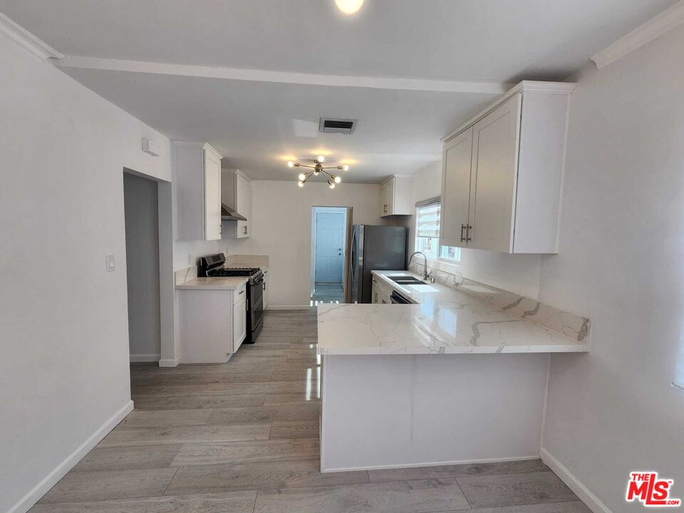 a large kitchen with kitchen island a sink stainless steel appliances and cabinets