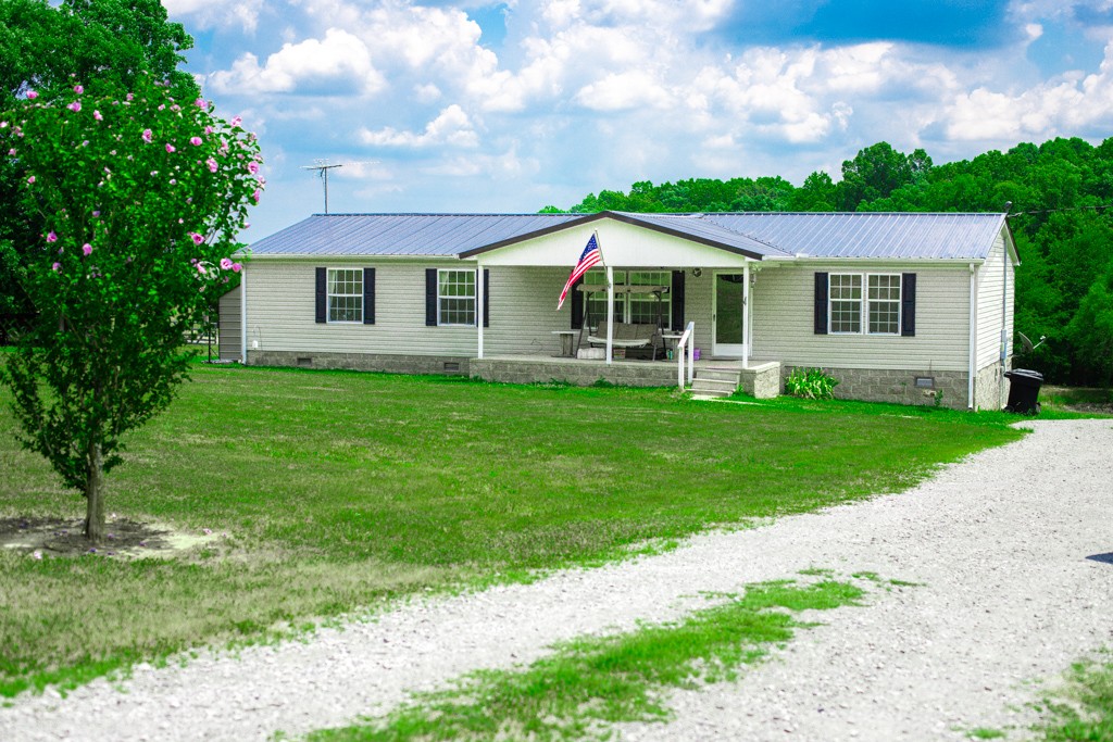 a front view of a house with a yard and green space