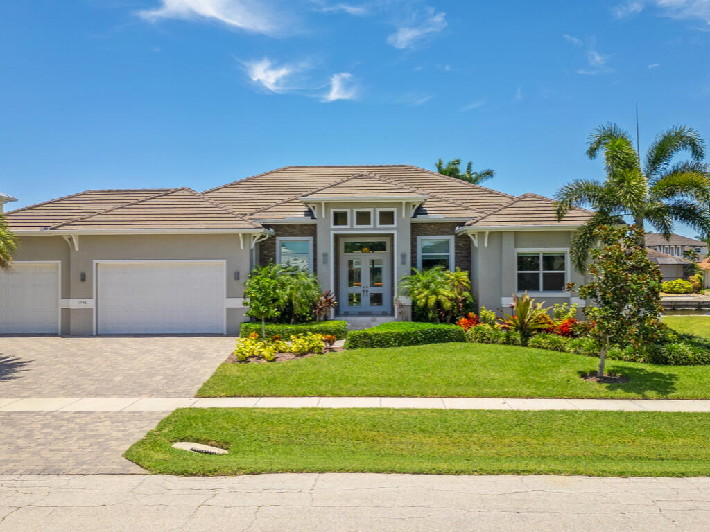 a front view of a house with a garden and yard