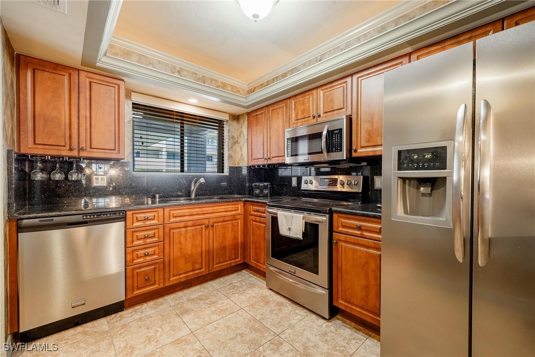 a kitchen with stainless steel appliances granite countertop a refrigerator a sink a stove top oven and a dishwasher