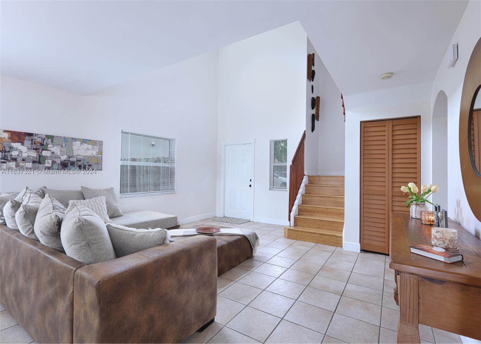 a living room with furniture and stairs