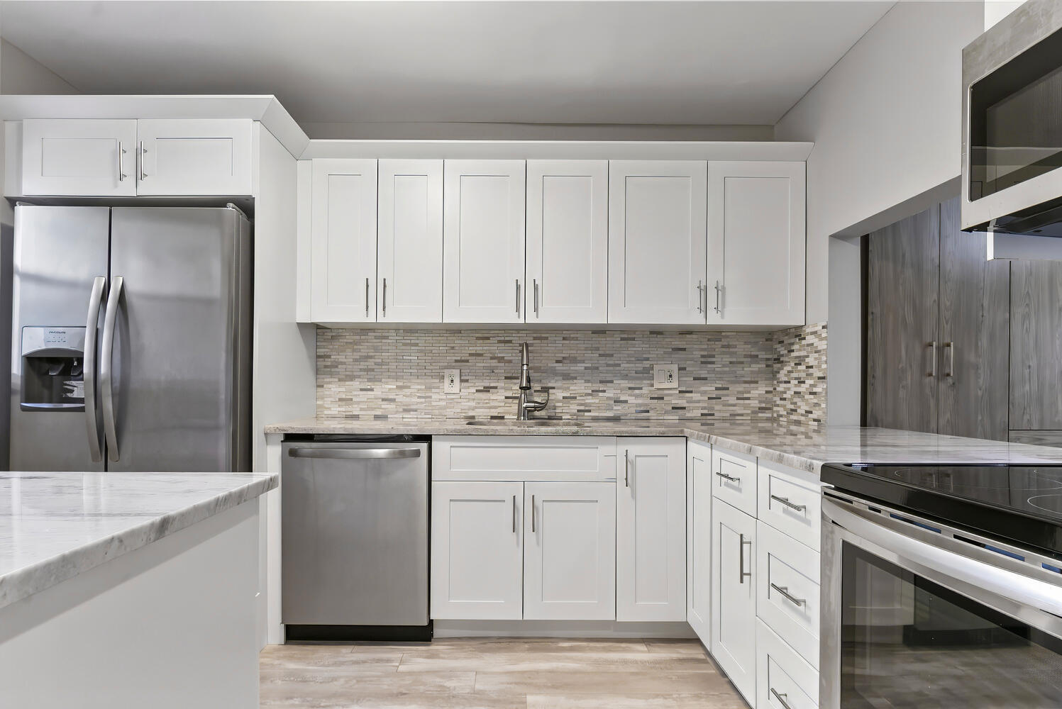 a kitchen with granite countertop a sink stove and refrigerator