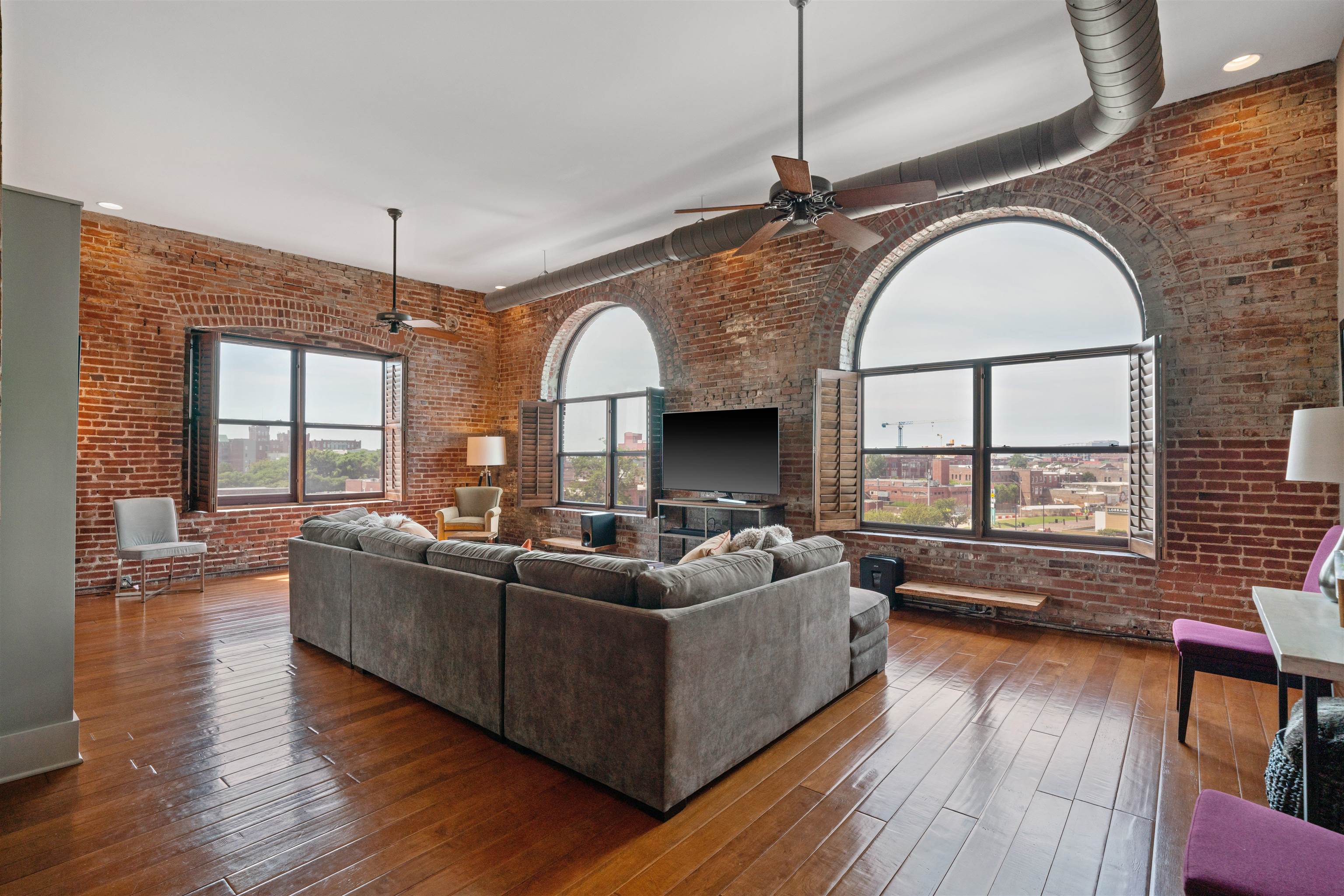 a living room with fireplace furniture and a large window