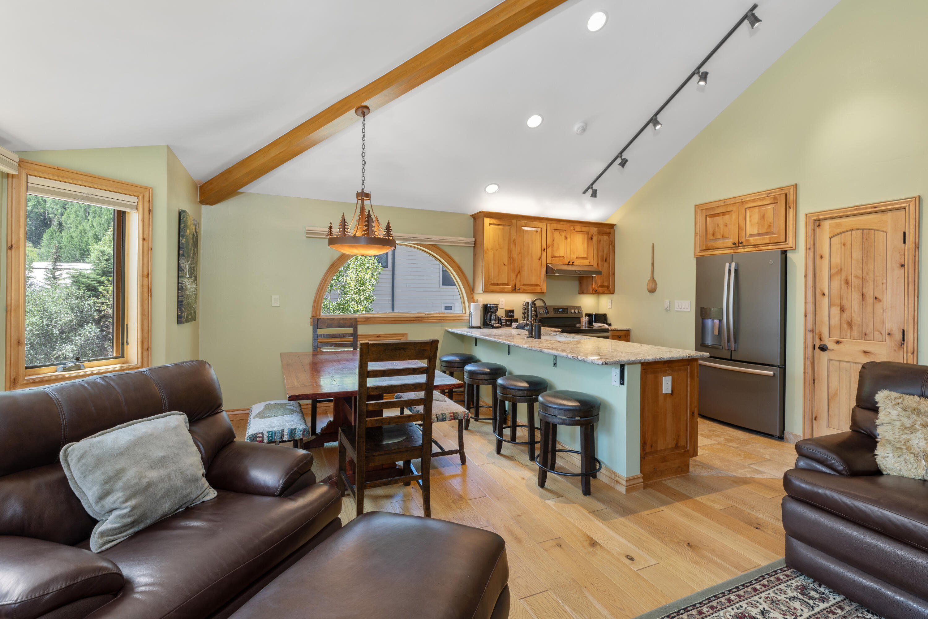 a living room with furniture kitchen view and a large window