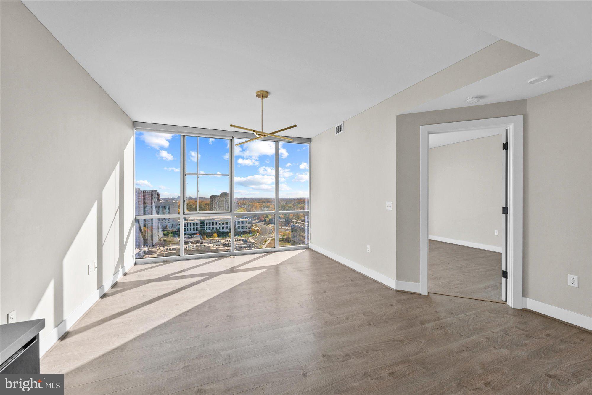 an empty room with floor to ceiling windows and outdoor view