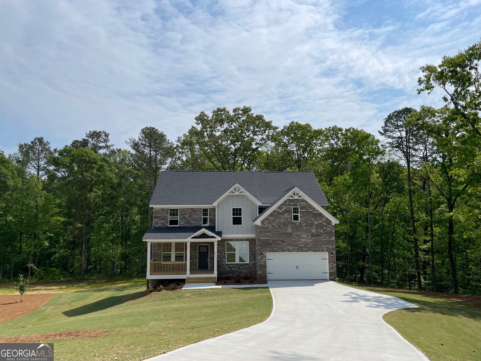 an aerial view of a house with a yard and large trees