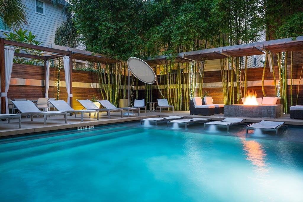 a view of pool with lawn chairs wooden floor and fence