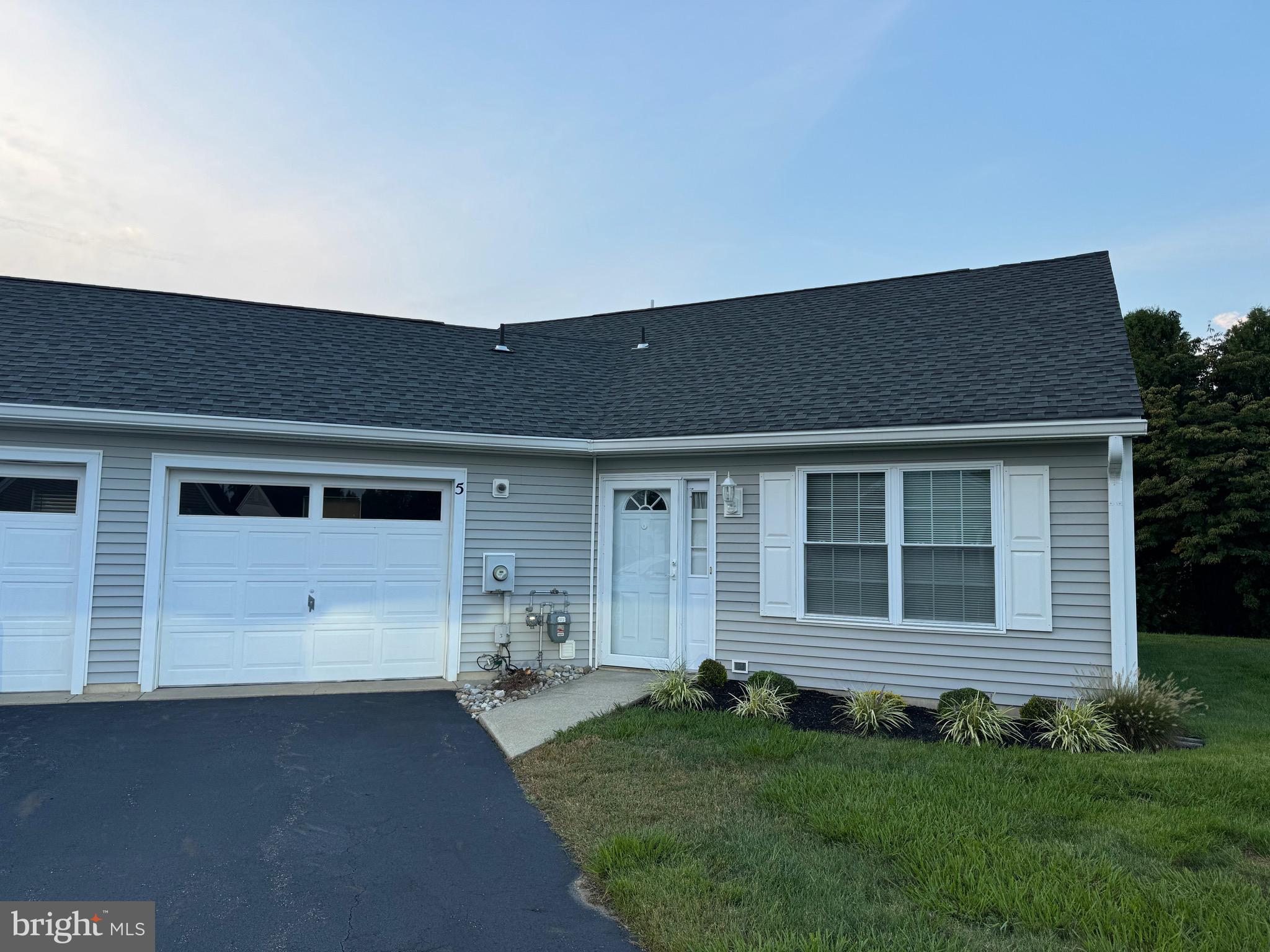 a front view of a house with a garden and garage