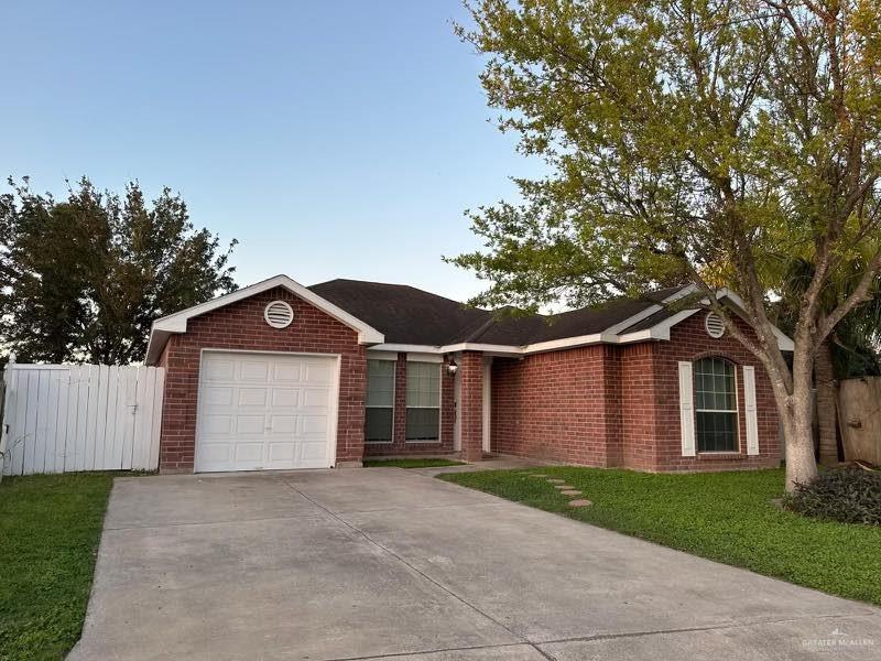 Ranch-style house with a front yard and a garage