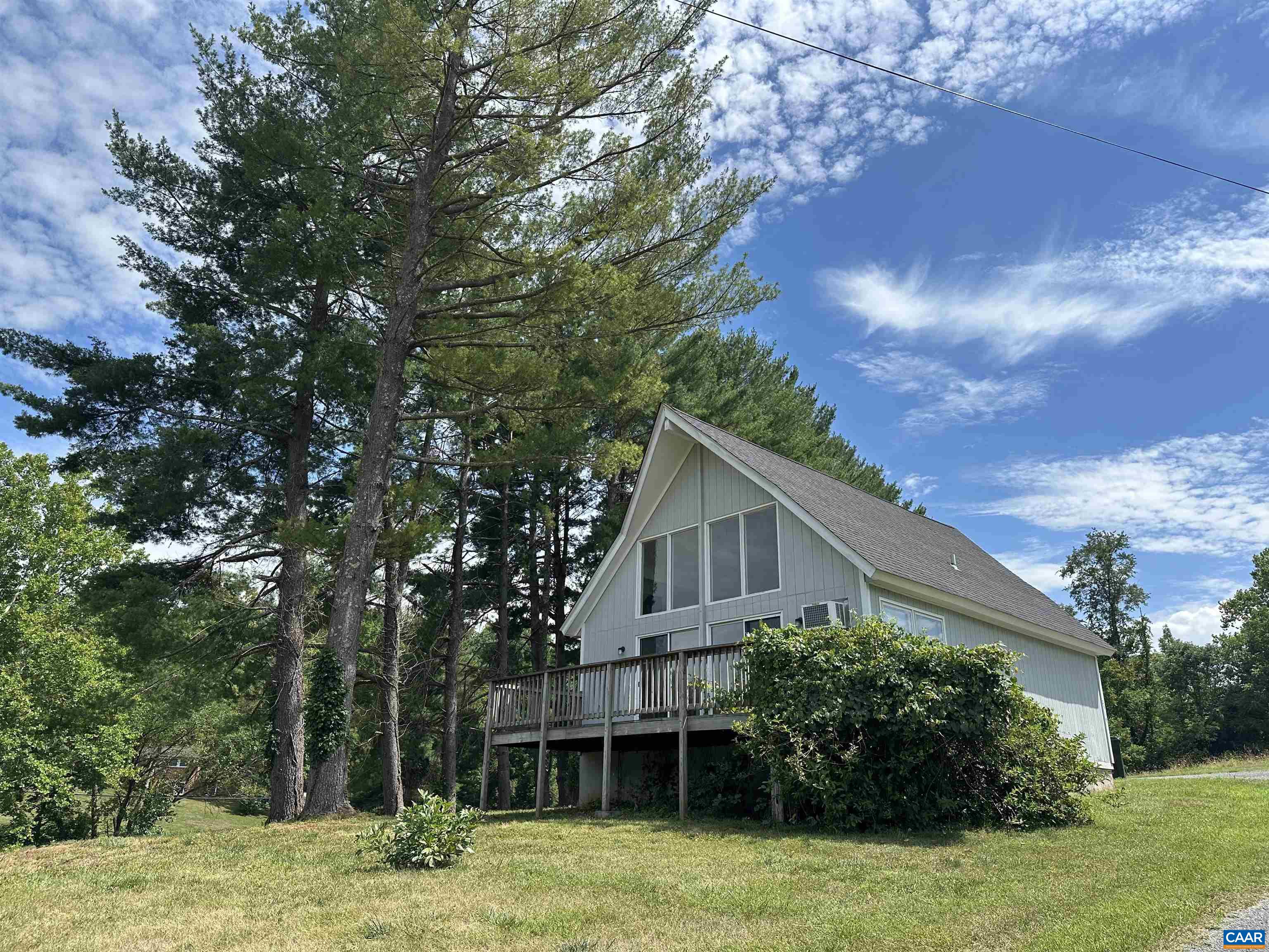 a front view of house with yard and trees around