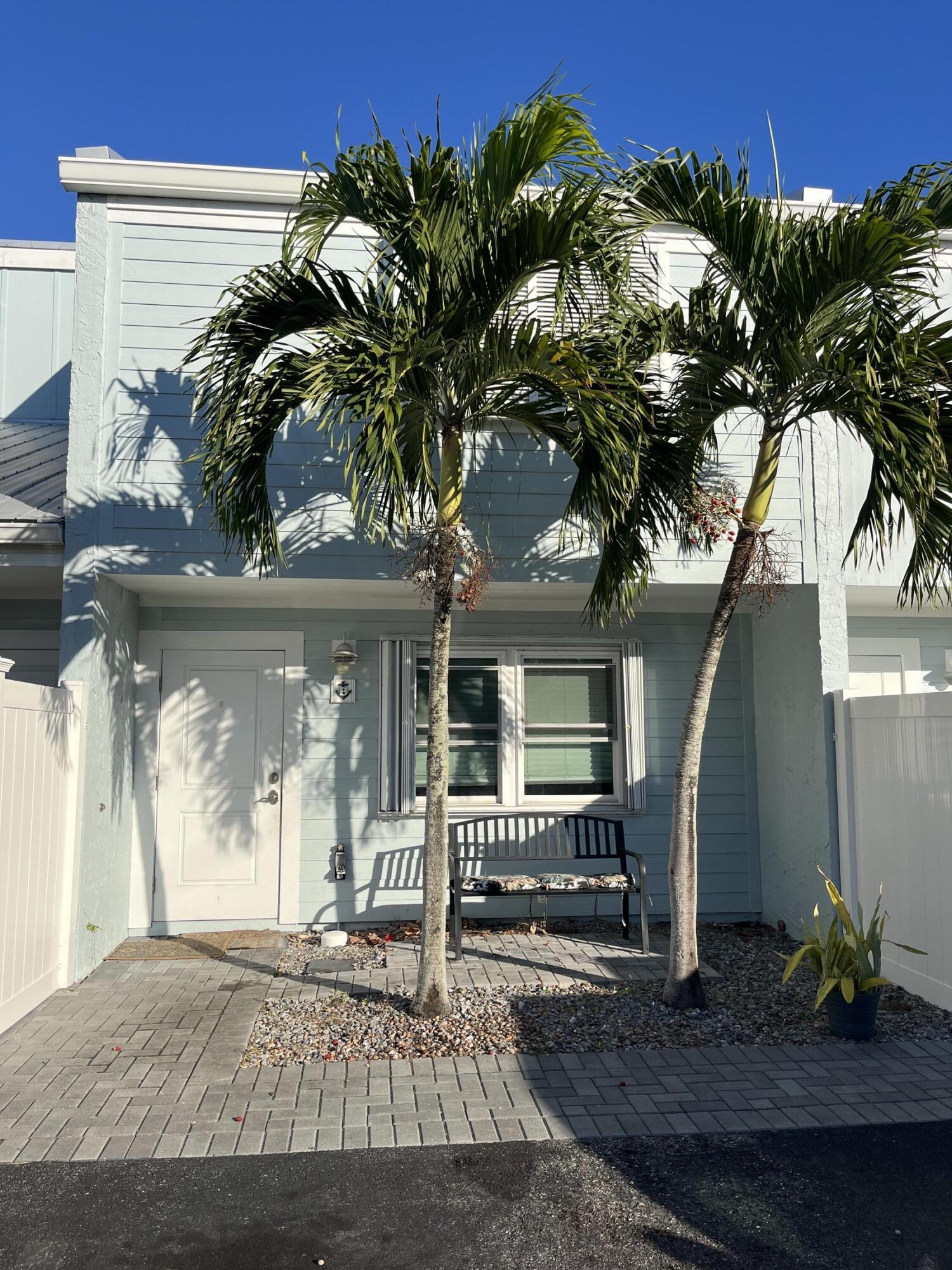 a front view of a house with a tree