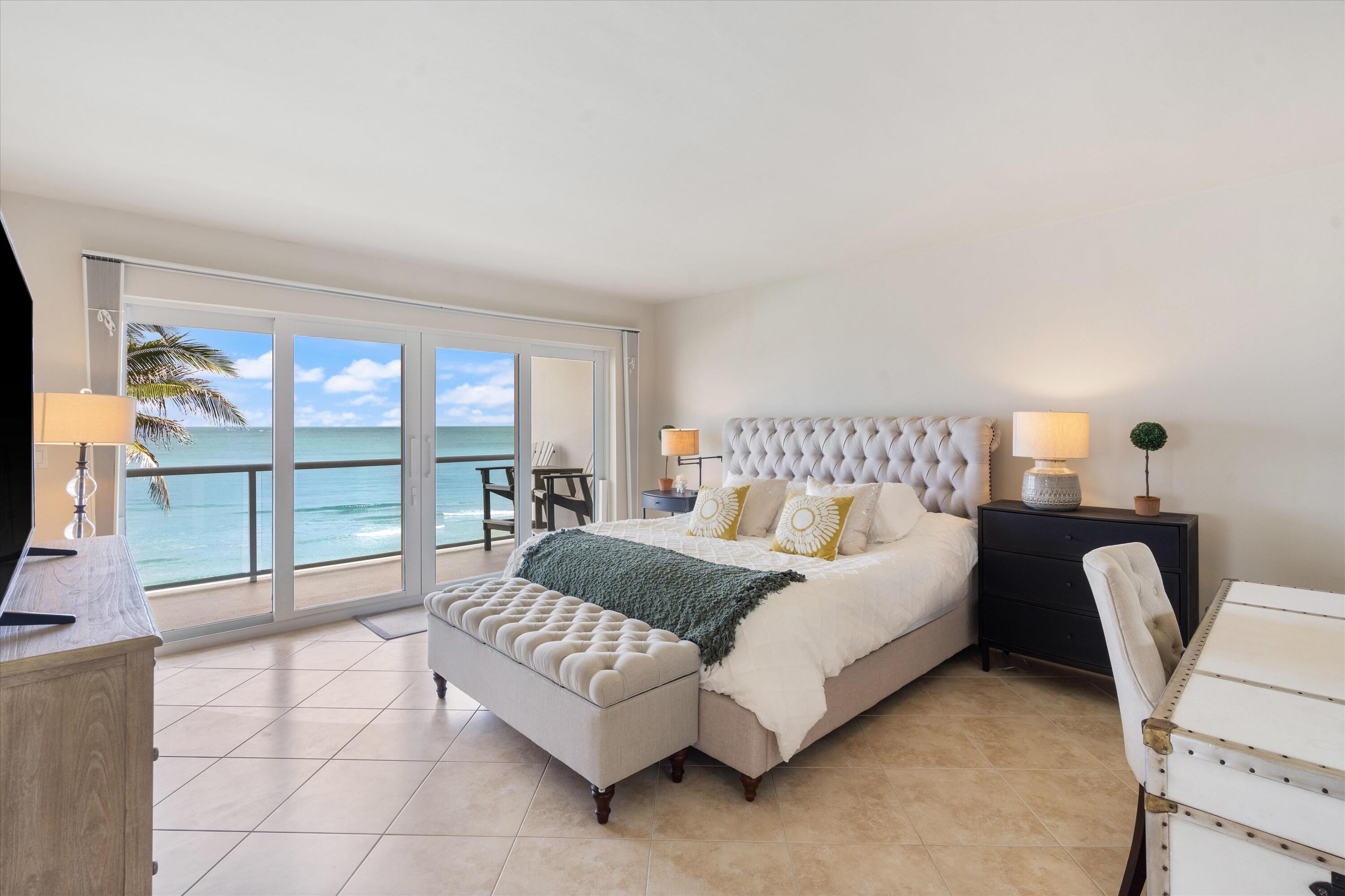 a spacious bedroom with a bed and a flat tv screen next to a large window