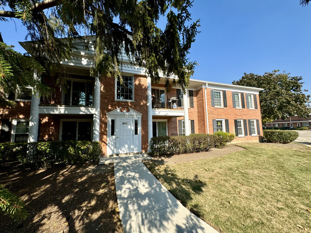 a front view of a building with a garden