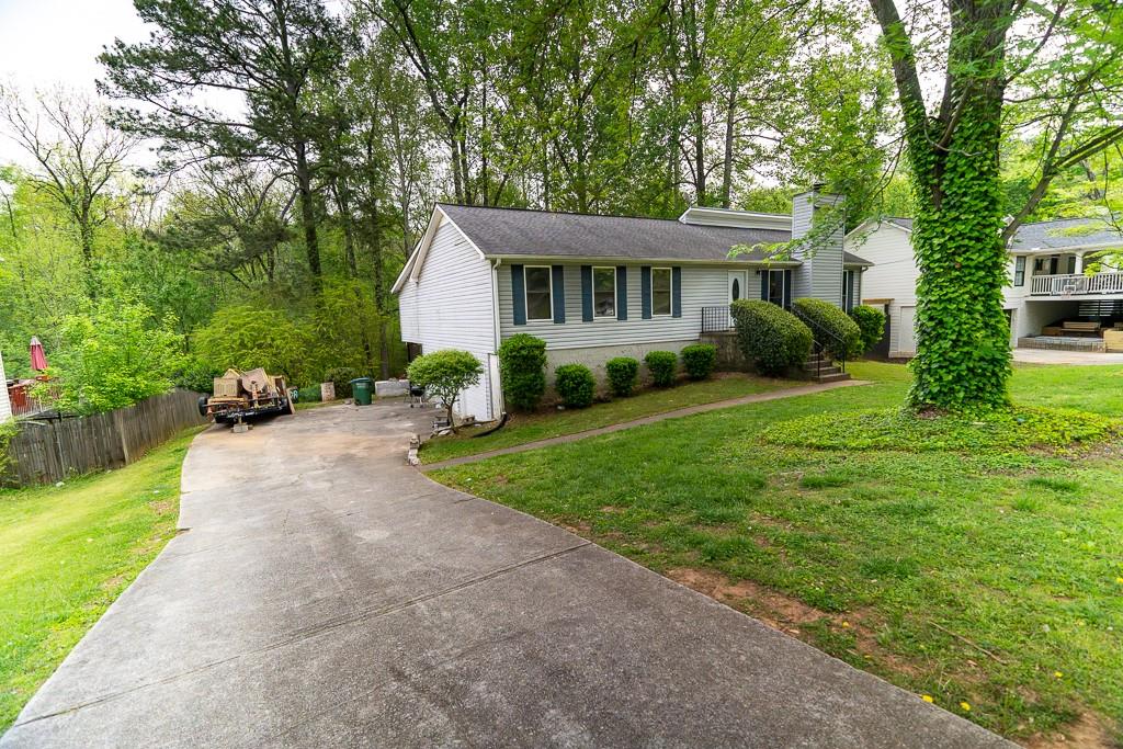 a view of a house with a yard and potted plants