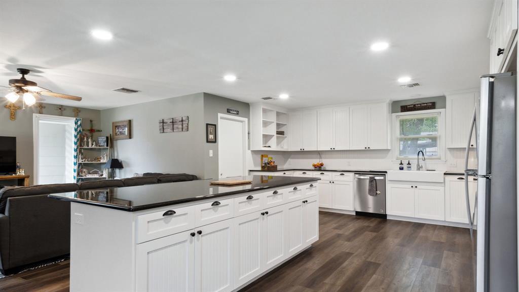 a kitchen with granite countertop a sink stove and refrigerator